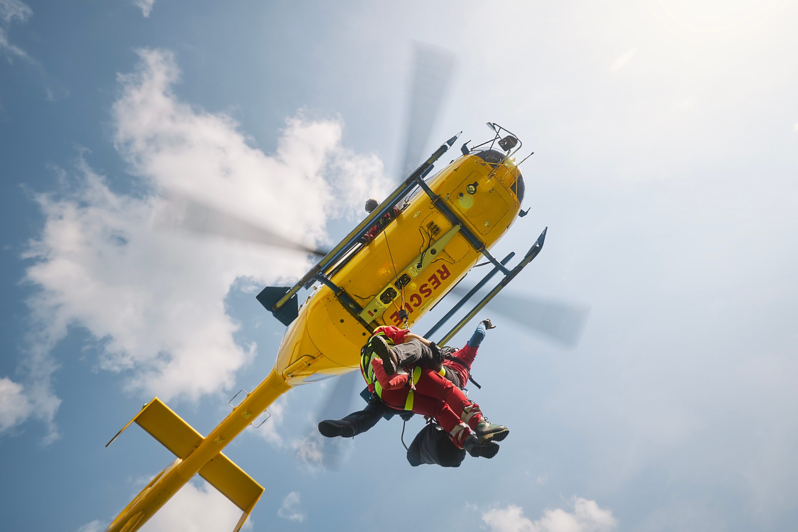 two,paramedics,hanging,on,rope,under,flying,helicopter,emergency,medical